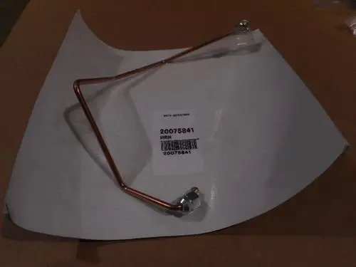 Remeha Ölröhrchen aus Kupfer, in gebogener Form mit einer Metallanschlussmutter. Liegt auf einem weißen Blatt Papier mit Produktlabel.